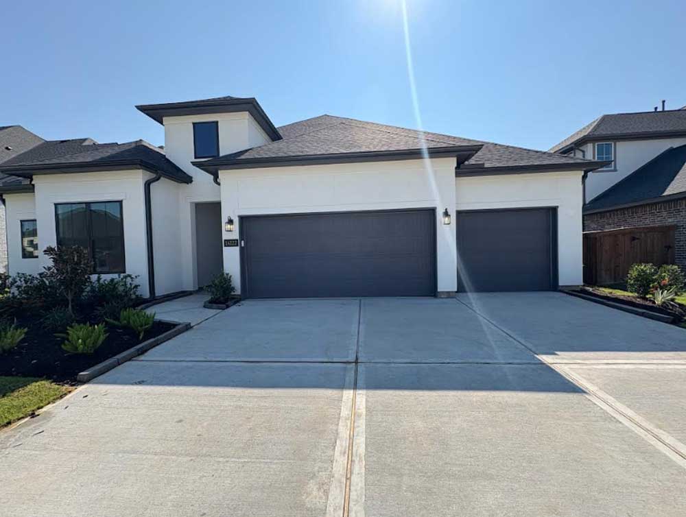 Modern home with dark three-car garage doors