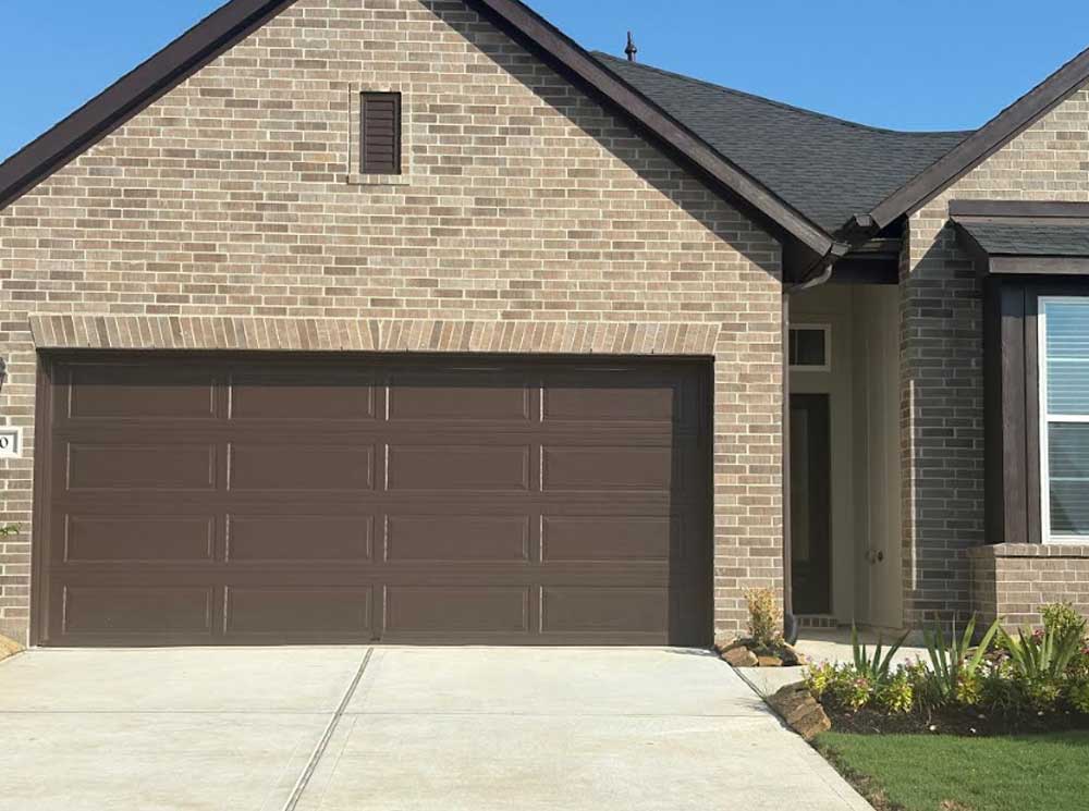 Brown panel garage door on a brick home